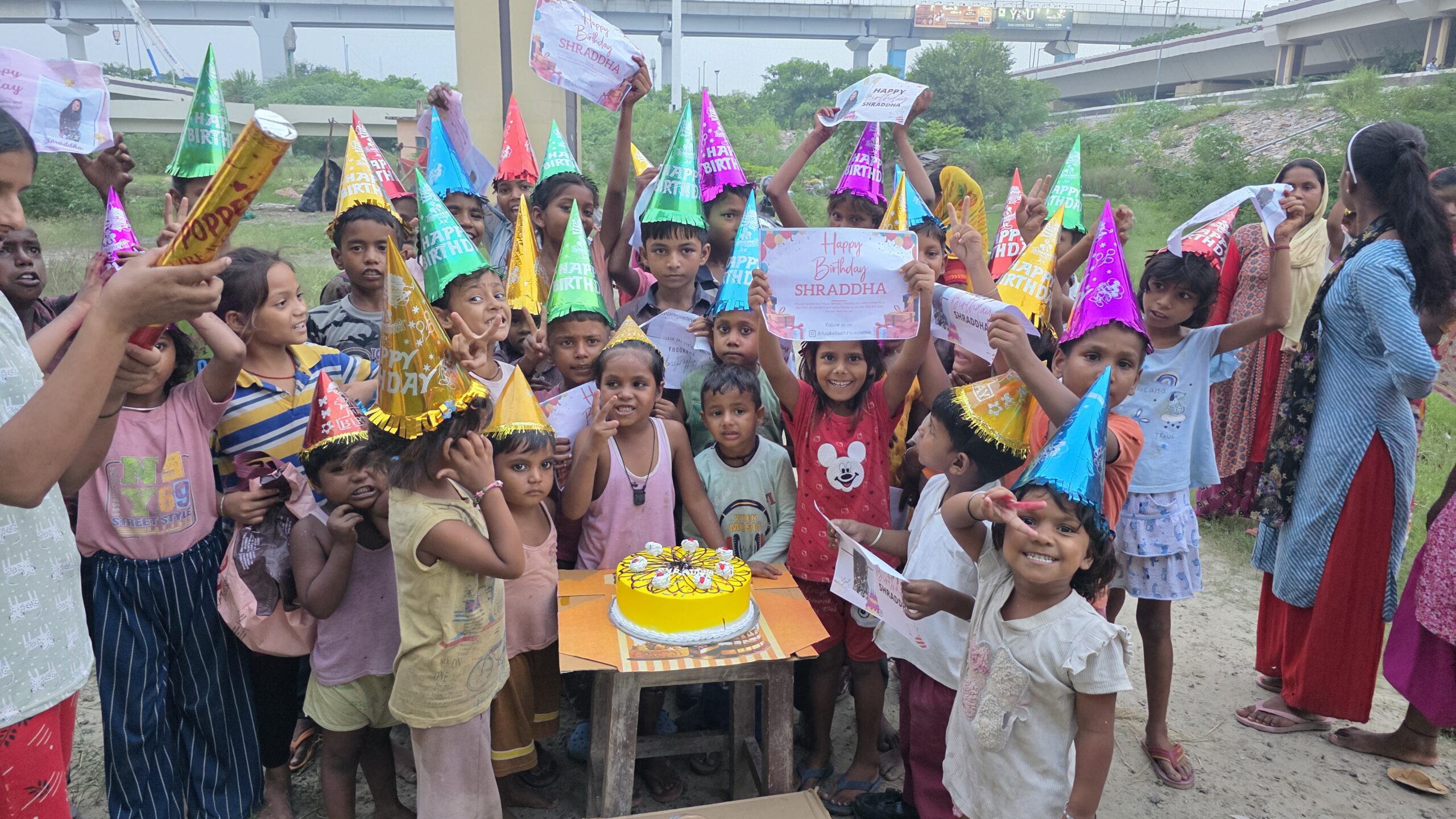 Underprivileged children smiling with food packets during a charity birthday celebration